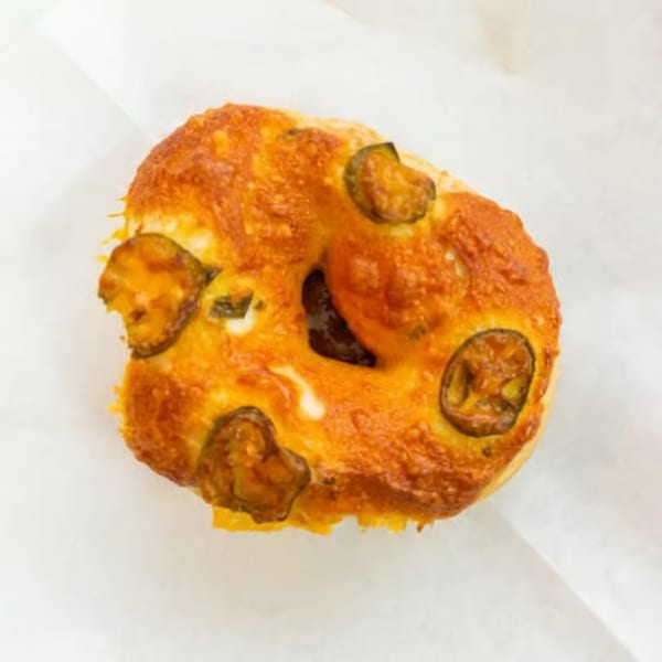 Raceway Bagels' jalapeño cheddar bagel, golden brown with melted cheese and sliced jalapeños.