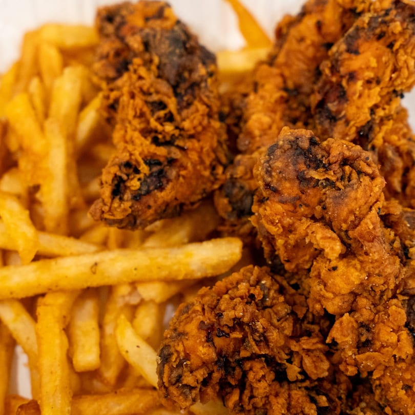 Crispy fried chicken tenders with golden french fries, a classic side dish at Raceway Bagels.