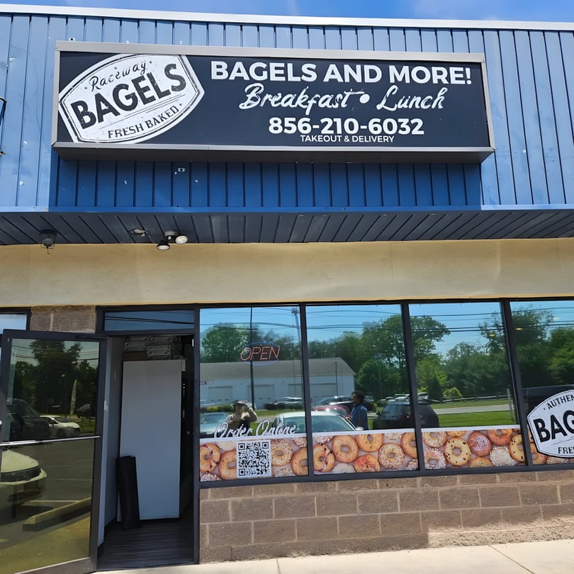 Exterior of Raceway Bagels with a large sign and window decals featuring bagels.